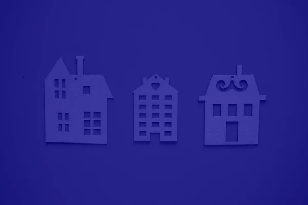 Home and building insurance. A secure future for your home. Flat wooden houses on blue background view from above. Blurred background.
