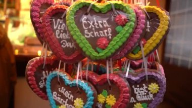 A stand with colorful Christmas gingerbread in the shape of a heart close-up. New Years Fair. christmas market in old city. Christmas cozy atmosphere. Christmas food. Selective focus