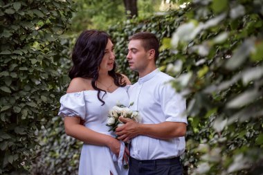 Bride and groom in a park kissing. Happy couple newlyweds bride and groom at a wedding in nature green forest are kissing photo portrait. Wedding Couple.