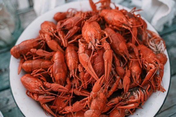 Rustic style large bowl with boiled crawfish, and on a grey-blue background.