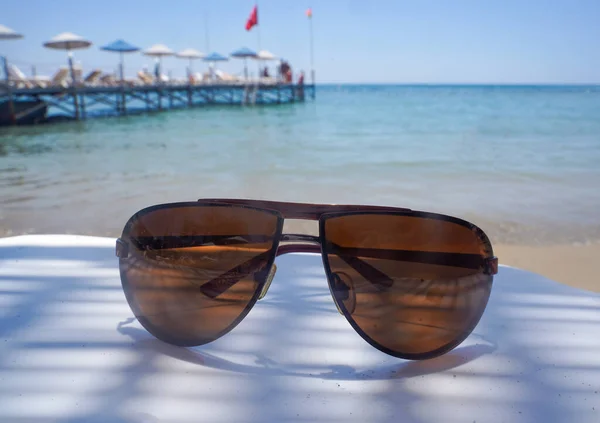 Sunglasses Lie Plastic Table Beach Backdrop Sea — Stockfoto