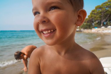 Deniz kıyısında mutlu bir çocuk yakın planda. Denizde yaz tatili.