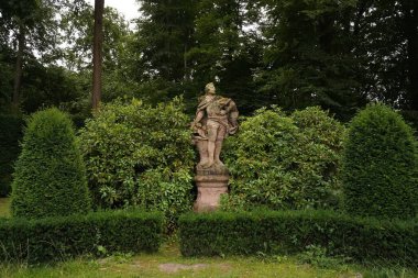 Bremen, Almanya - 17 Ağustos 2022: figür ağaçlardan oluşan bir bahçede bilinmeyen bir adamın heykeli. Peyzaj.