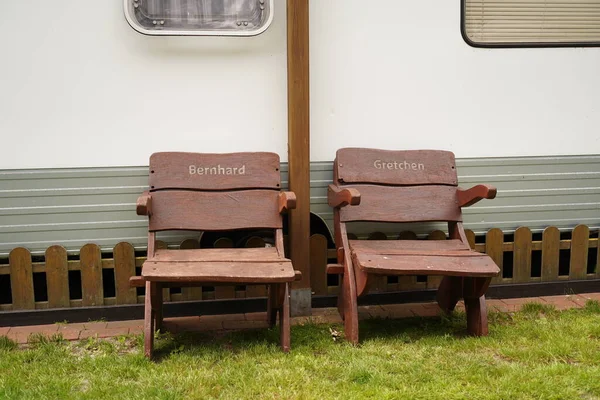Two vintage wooden chairs with names in front of the house close-up. Quiet old age.