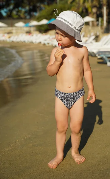 Ребенок Плавках Шляпе Берегу Моря Вкусно Поедающий Леденец Отдых Берегу — стоковое фото