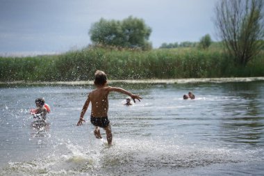 Genç çocuk göle atlıyor.