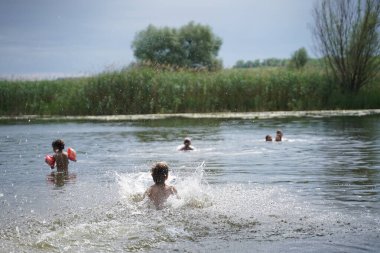 Mutlu bir çocuk denizde oynar. Çocuk temiz havada eğleniyor. Yaz tatili ve sağlıklı bir yaşam tarzı. Seçici odak.