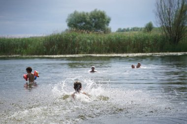 Mutlu bir aile ya da sahilde gün batımı nehrinde koşup zıplayan arkadaşlar. Arkadaşlık ya da tatil kavramı. Seçici odak.