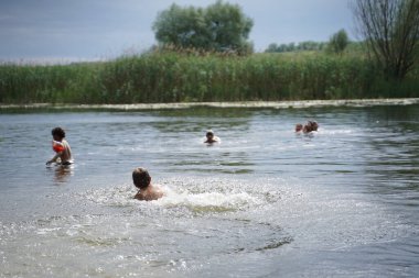 Yaz nehrinde su sıçratan çocuklar. Seçici odak.
