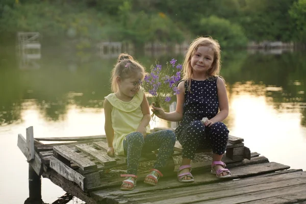 Meninas Namorada Sentar Com Flores Cais Lago Rir Alegremente Foco — Fotografia de Stock