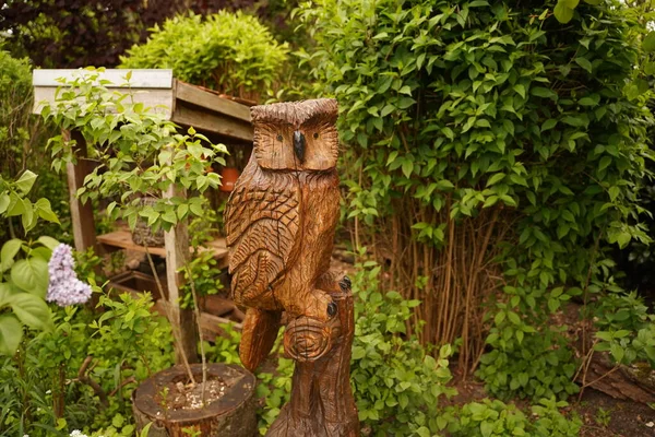 Owl statue on a wooden base in the garden for selective focus and background of spanish moss