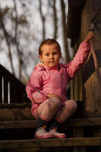 漂亮的粉红女郎坐在木制台阶上 — 图库照片