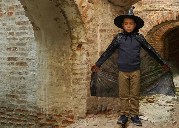 stock image A boy wizard with his eyes closed and his hands spread stands in the ruins of an ancient castle.