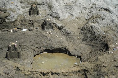 Kumsaldaki ıslak kumdan yapılmış evler. Deniz kıyısında kumlu bir kasaba. Güzel kumdan kaleler.