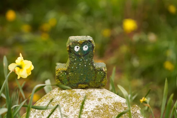 Stone figure of a frog in the summer garden. Original garden decor DIY