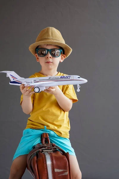 Dziecko Letnich Ubraniach Okularach Siedzi Walizce Trzyma Rękach Zabawkowy Samolot — Zdjęcie stockowe