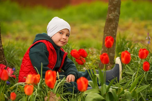 Roztomilé Dítě Sedící Podzimní Zahradě Čichající Fialovému Pupínku Tulipánu Chlapeček — Stock fotografie