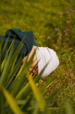 Çocuk bir çalılığın arkasına saklandı ve dışarı baktı. Seçici odak