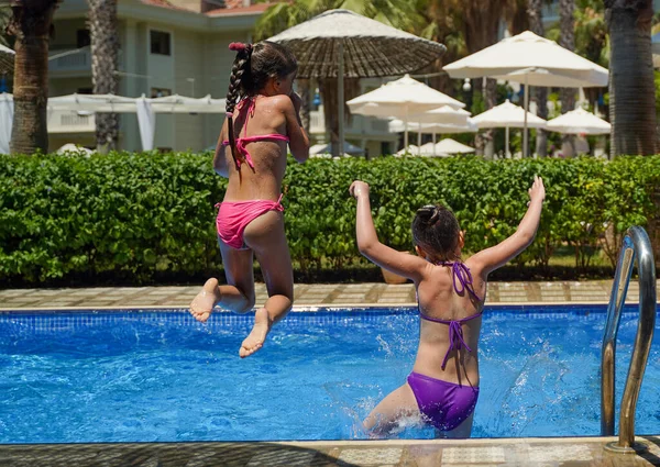 Duas Meninas Saltando Para Piscina Vista Traseira Tropical Diversão Férias — Fotografia de Stock