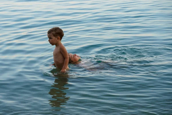 stock image A little boy lifeguard drags his friend out of the water to the shore. The concept of mutual assistance and friendship. Children's safety in the water