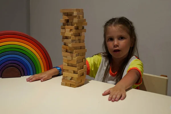 A little girl builds a pyramid of blocks. The concept of early childhood development