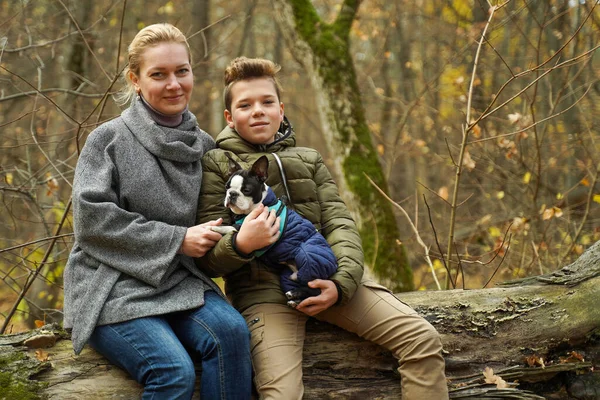 Ormanda köpeği olan mutlu bir aile. Anne ve oğlu evcil bir hayvanla yürüyüşe çıktılar.