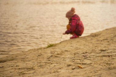 Yalnız bir çocuk bir göletin kıyısında oturur. Odaklanamayan atış, kuma odaklan. Yalnızlık ve sonbahar