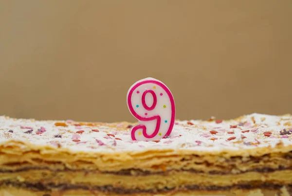 Birthday layer cake with candle number 9 nine close-up. Birthday cake or anniversary