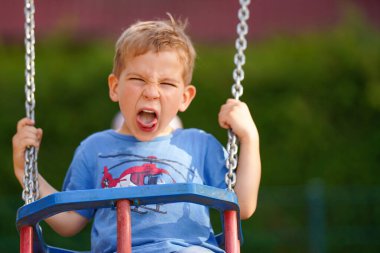 Salıncaktaki kaprisli bir çocuk. Ebeveynlik. Okul öncesi eğitim