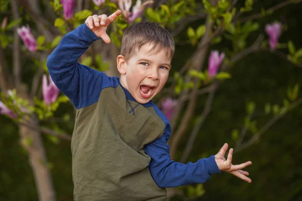 小男孩在一棵开花的树的背景下跳舞 快乐的童年 — 图库照片