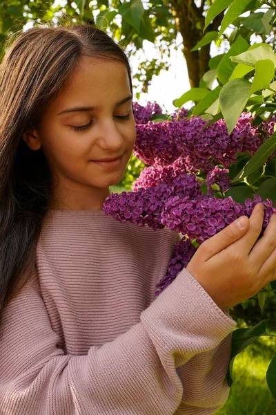 穿着紫色衣服 头戴紫丁香花的漂亮姑娘 具有紫丁香的小女孩的画像 春天的心情 — 图库照片