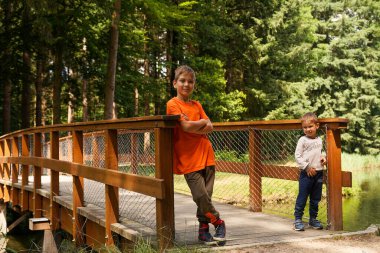 Köprünün yakınındaki bir parkta iki çocuğun portresi. Aile tatili