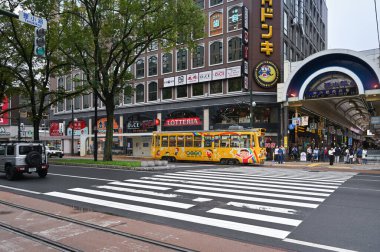 Sapporo, Japonya - 27 Eylül 2024: Yerel tramvay Tanukikoji Alışveriş Caddesi 'nden geçiyor
