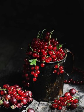 red currant with leaves and berries on a dark background.