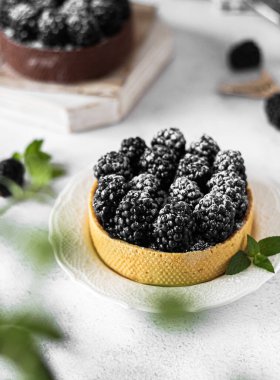 homemade tartlets with blackberries in a metal bowl on the table