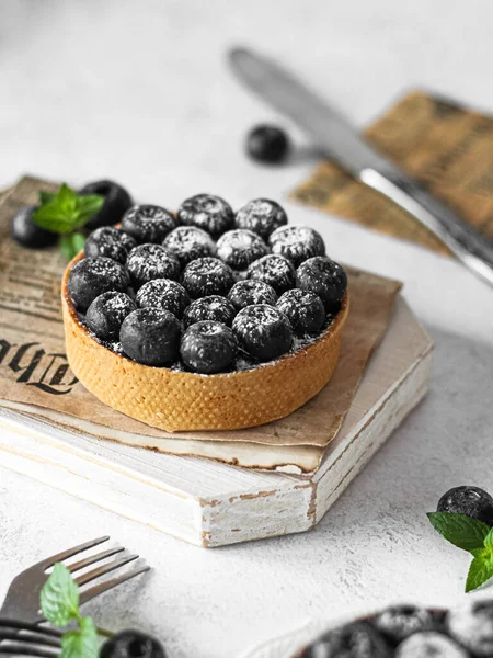 delicious homemade blueberry tartalet over wooden background. selective focus