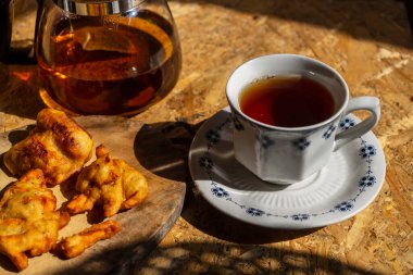 Herbal tea and teacup served with sweet potatoes fries on wooden table