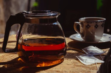 Hot tea with teapot on blur background