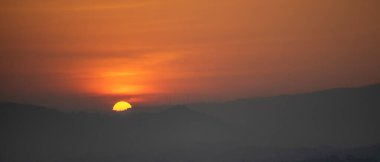 Güneşin dağın diğer tarafındaki günbatımı arkaplan görüntüsü