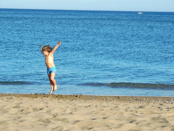 Szczęśliwy Mały Chłopiec Spacerujący Plaży Niebieskim Tle Nieba — Zdjęcie stockowe