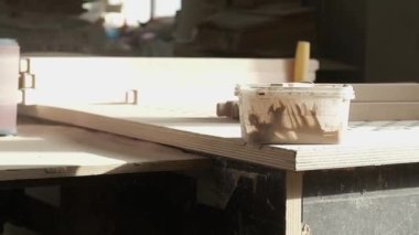 Bir marangoz mobilya fabrikasında ahşap bir parça zımparalıyor..