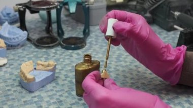 Bir klinikteki takma diş laboratuvarında çalışan dişçi teknisyeninin yakın çekimi..