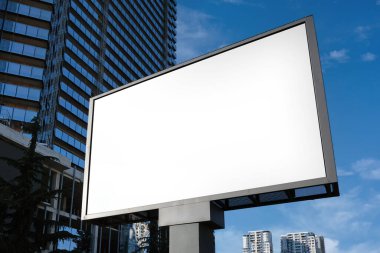 Şehrin sokaklarında reklam için büyük bir bilgi gösterisi, bir gökdelenin ve güzel bir gökyüzünün arka planına karşı..