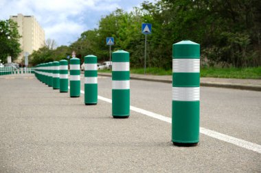 Şehirdeki trafiği düzenlemek için bir sürü kısıtlayıcı yeşil plastik kutup. Seçici odak.