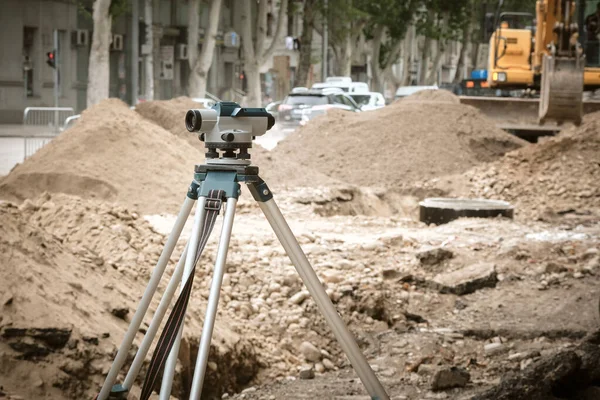 Close-up of a laser level or level that determines the difference in heights of points on the earth\'s surface during the construction or repair of roads in the city. The work of utilities to improve the infrastructure of the metropolis. Reconstructio