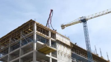 İşçiler beton dökmek için demirden bir kemer yapıyorlar. Şehirde yeni bir konut inşaatı