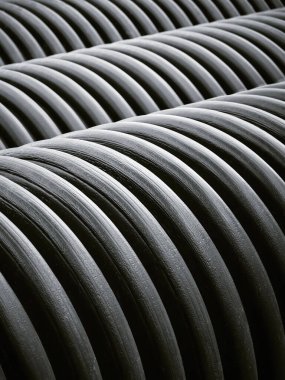 Su temini için geniş siyah plastik boruların dikey görüntüsü. Şehirdeki boru hattı ve kanalizasyonun yeniden inşası. Tasarım şablonu.