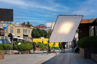 Şehirdeki caddelerde televizyon veya film çekmek için bir sürü aydınlatma donanımı ve ekipman var..