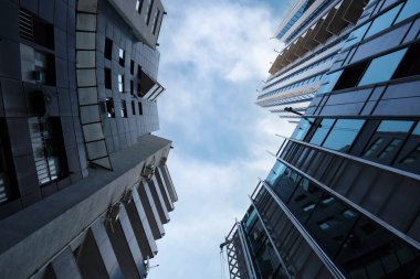 Güzel, modern bir ofis gökdeleninin, bir apartmanın yanına inşa edilmesinin alt manzarası. Dış yapı, iş, inşaat endüstrisi gökyüzüne karşı..