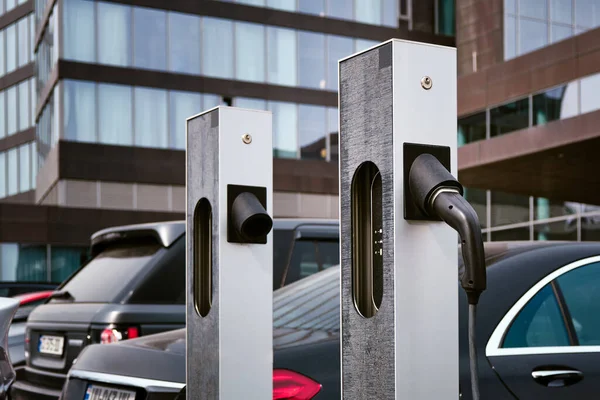 乗用車の背景に対して市内の電気自動車を充電するためのステーションの閉鎖 — ストック写真